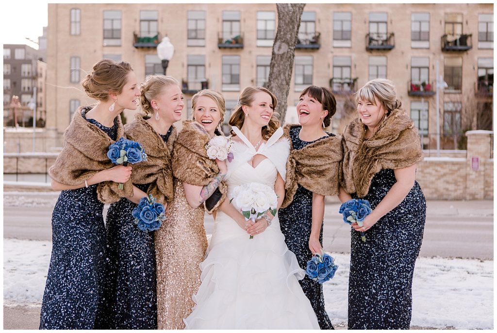 city wedding photos, fur shawls, cupcake wedding dress, sparkly blue bridesmaid dresses, champagne maid of honor dress, winter wedding inspiration, candid bridal party photos