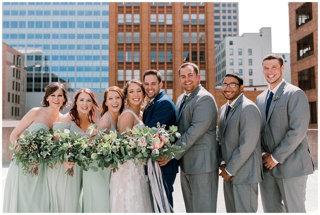 Wedding party smiling on Minneapolis rooftop
