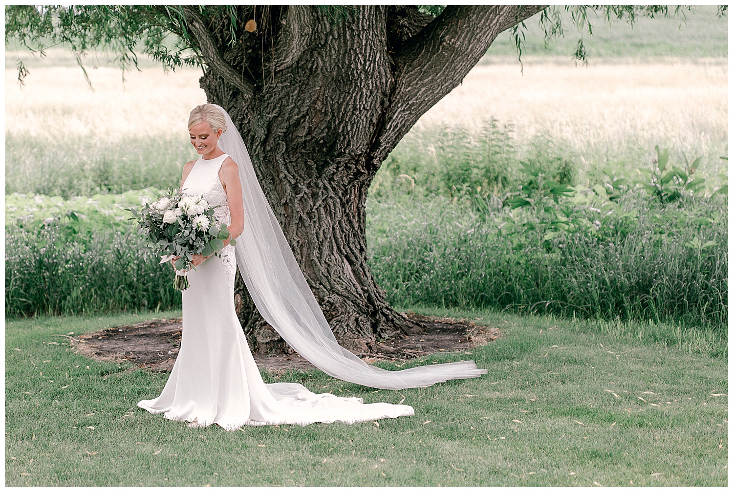 Bridal portrait session bride looking at bouquet with willow tree