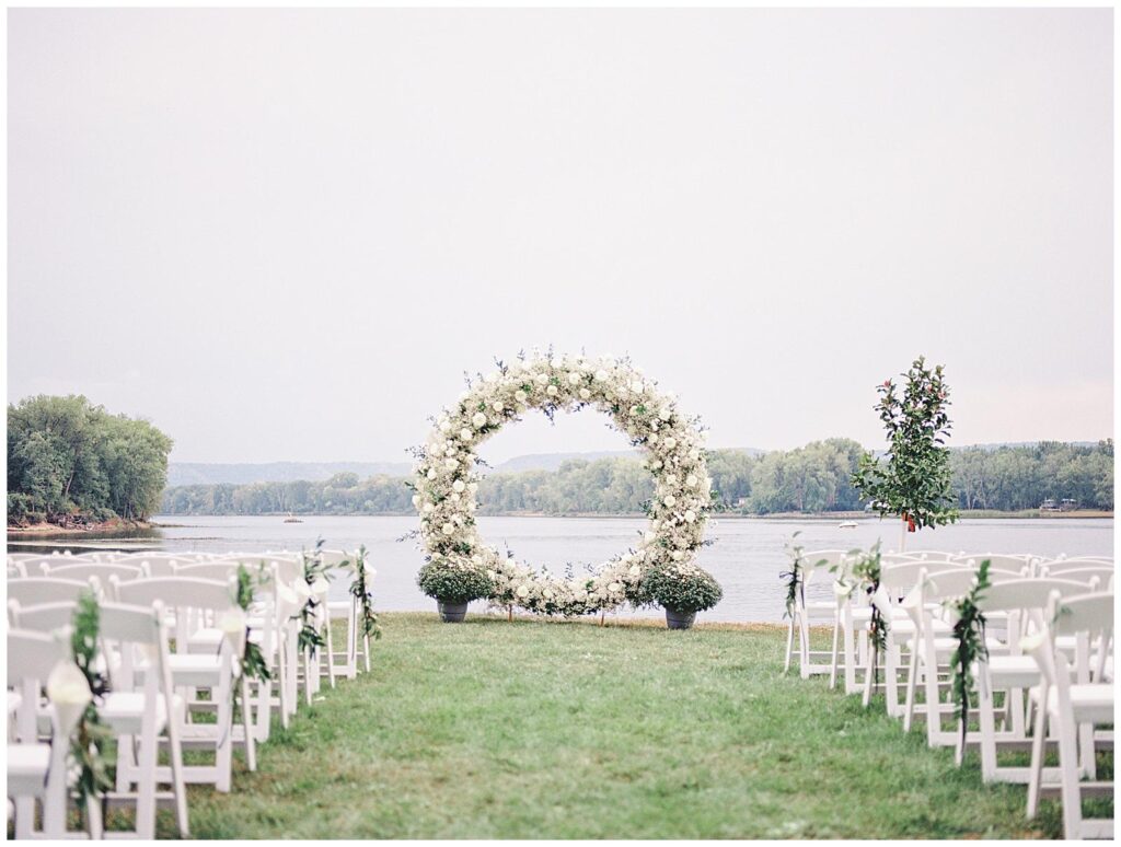Lush white ceremony floral arch at a tented Wisconsin wedding