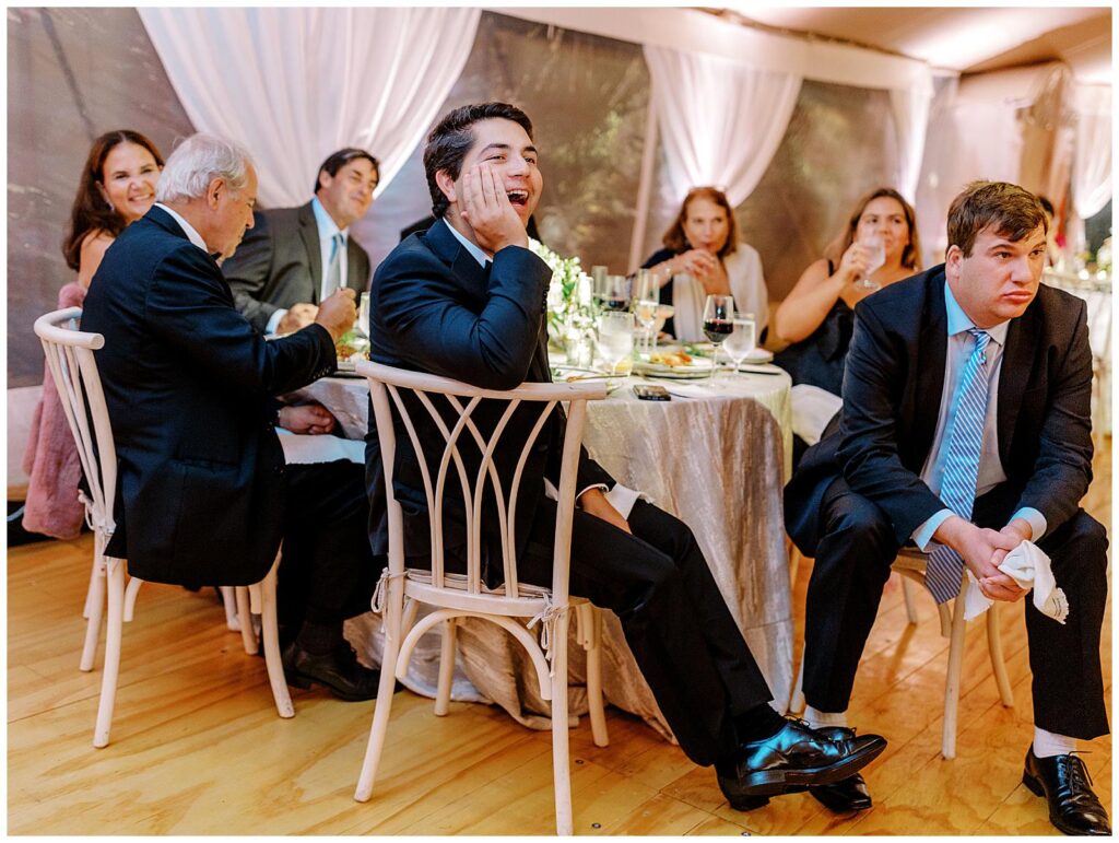 Guests watch and laugh at a toast.