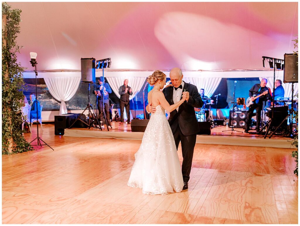 The bride and her dad dance together.