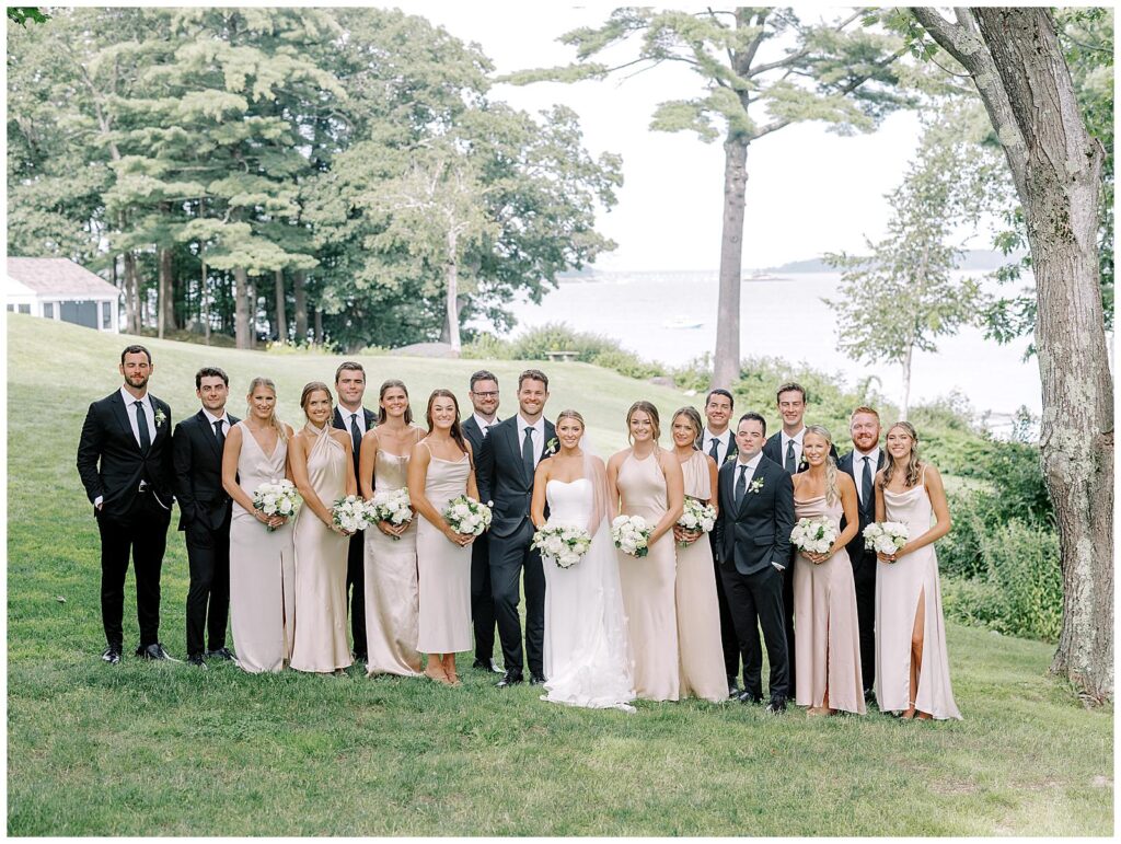 Full wedding party in black and pink champagne attire in their Maine wedding photos