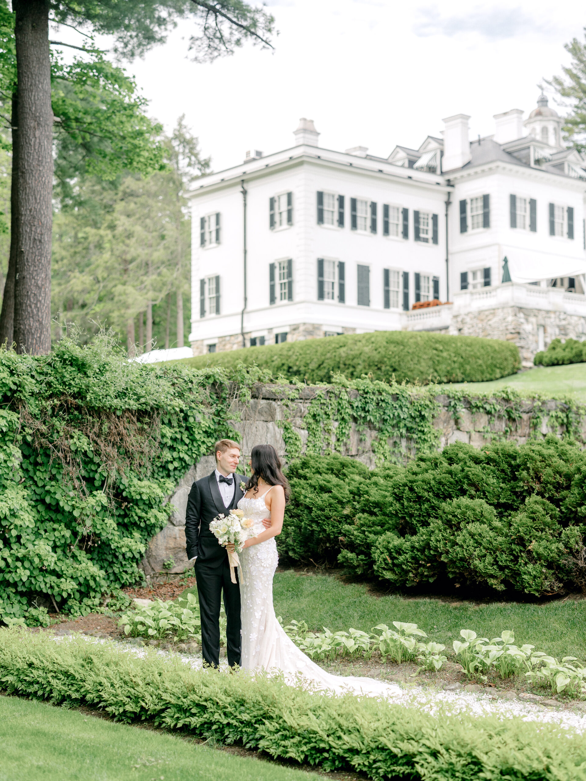 Bride and groom in the Italian Garden with The Mount wedding venue in the background